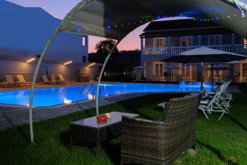 a patio with a table and chairs next to a pool at Katsaros Studios & Apartments in Sidari