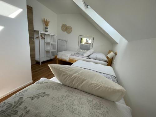 a attic bedroom with three beds and a staircase at Apartma Guide 360 in Bovec