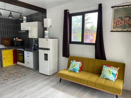 a living room with a couch and a kitchen at Rangiroa Cottage in Avatoru