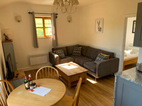 een woonkamer met een bank en een tafel bij Ashton Cottages in Wedmore