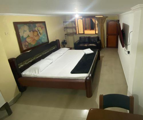 a bedroom with a large bed and a couch at Hotel Caldas Plaza in Caldas