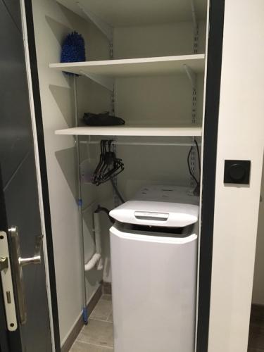a small kitchen with a white refrigerator and shelves at MONT BLANC HOLIDAYS dans résidence avec Gardien in Sallanches