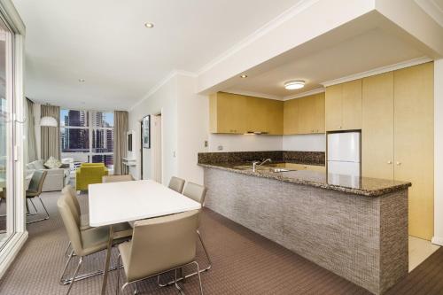 a kitchen with a table and chairs and a refrigerator at Clarion Suites Gateway in Melbourne
