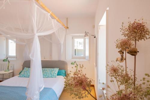 a bedroom with a bed with a canopy at Casa no Rio - River House in Vila Nova de Milfontes