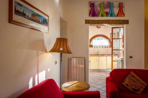 a living room with a red couch and a lamp at CASE&COLLINE Villa Grazia in Montescudaio