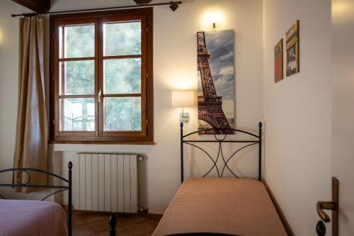 1 Schlafzimmer mit 2 Betten und einem Fenster in der Unterkunft CASE&COLLINE Villa Grazia in Montescudaio