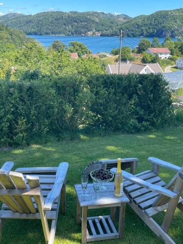 two chairs and a table with wine glasses on it at Jåsund SunView in Lyngdal