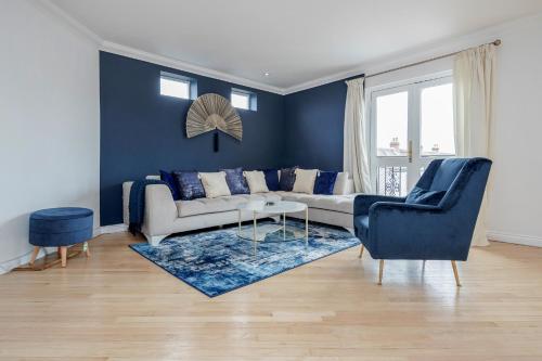 a living room with a couch and a blue wall at Large Penthouse by Damask Homes with Parking in Redbridge