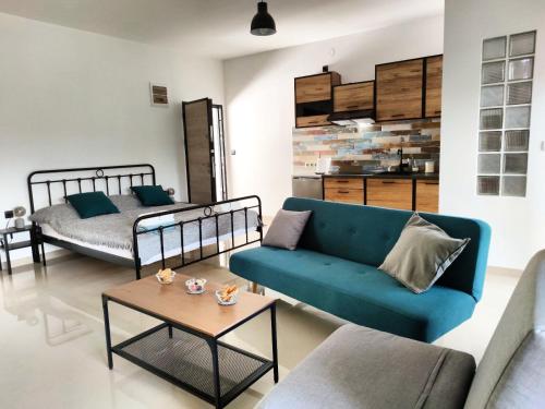 a living room with a blue couch and a bed at Anchor house in Volos