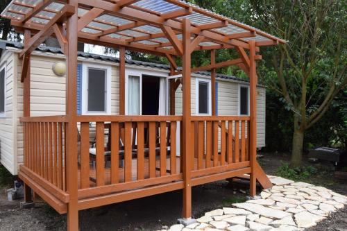 a wooden gazebo with a deck next to a house at Penzion Betty in Okounov