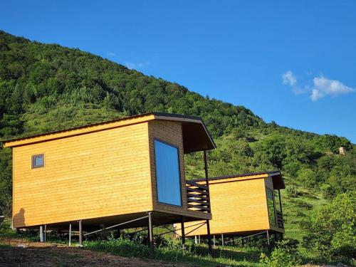 une maison avec une grande fenêtre sur le côté d'une colline dans l'établissement Georgian exotic cottages, 