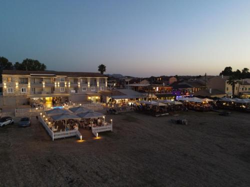 a building with tables and umbrellas at night at Aqua Luxury Suites by Estia in Roda