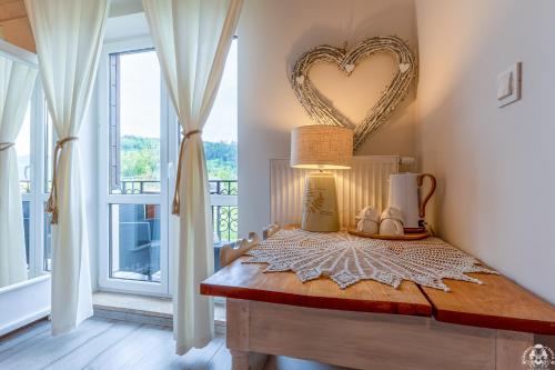 a room with a table with a heart mirror on the wall at Agroturystyka Corno Owca in Żabnica