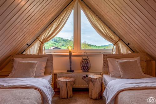two beds in a room with a window at Agroturystyka Corno Owca in Żabnica