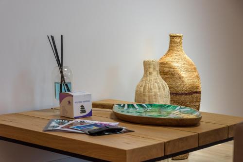 a table with two vases and a plate on it at Résidence Ochji di Mare in Propriano