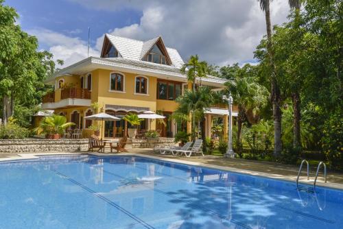 a house with a swimming pool in front of a house at Casa Las Palmas Hotel Boutique in San Andrés