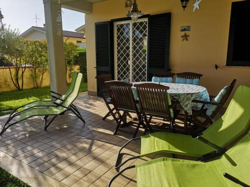 eine Terrasse mit einem Tisch und Stühlen auf einer Terrasse in der Unterkunft Cactus 2020 in Sabaudia
