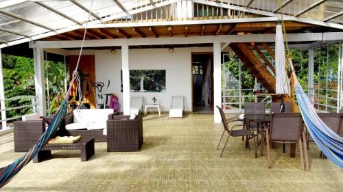 a porch with a hammock and a table and chairs at Villa Migelita Ecolodge in Palmira