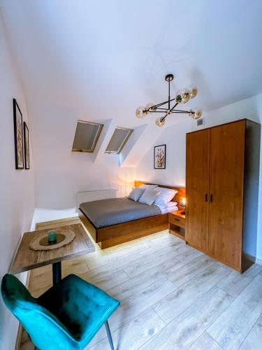a bedroom with a bed and a table and a chair at Domek pod Katalpami in Głowno