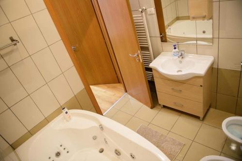 a bathroom with a bath tub and a sink at Sadara Sea Breeze in Mamaia Sat/Năvodari