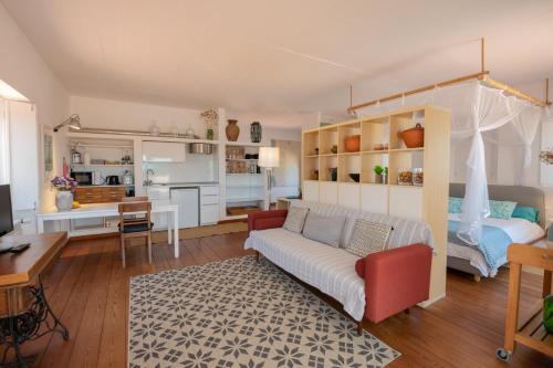 a living room with a couch and a bedroom at Casa no Rio - River House in Vila Nova de Milfontes