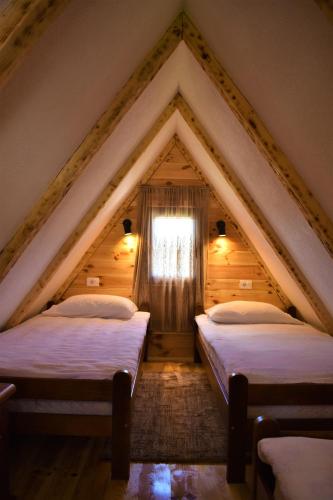 two beds in a attic with a window at Durmitor view - Bungalow in Žabljak