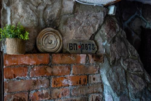 a brick wall with a sign on it with a plant at Lake House Buric in Vranjina