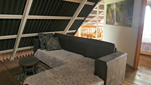 a living room with a couch and a stool at Villa Migelita Ecolodge in Palmira