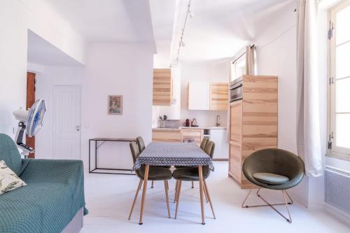 un salon avec une table et des chaises et une cuisine dans l'établissement Cosy 36m avec jolie VUE MER  centre-village !, à Bormes-les-Mimosas