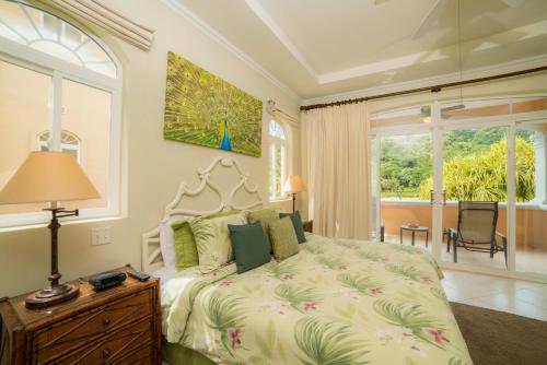1 dormitorio con cama y ventana grande en Los Suenos Resort Colina 15C by Stay in CR, en Herradura