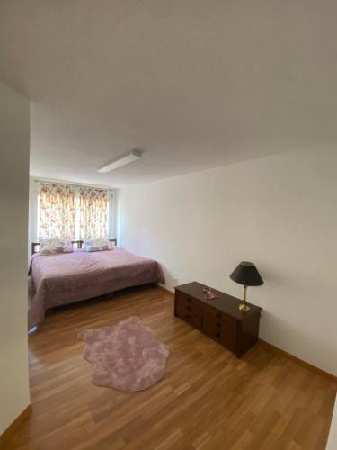 a bedroom with a bed and a table and a window at Get Cozy Family Flat Zürich in Zürich