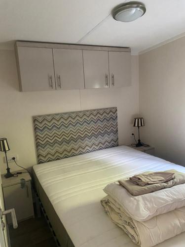 1 dormitorio con 1 cama blanca grande y armarios blancos en Mooi verblijf op rustig park, en Ermelo