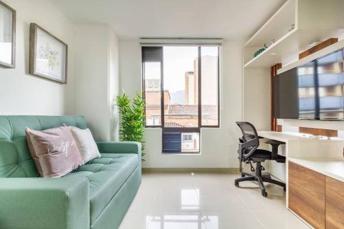 a living room with a green couch and a desk at Fabulous studio in the heart of Medellín in Medellín