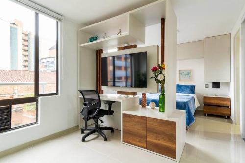 1 dormitorio con escritorio, 1 cama y espejo en Fabulous studio in the heart of Medellín, en Medellín