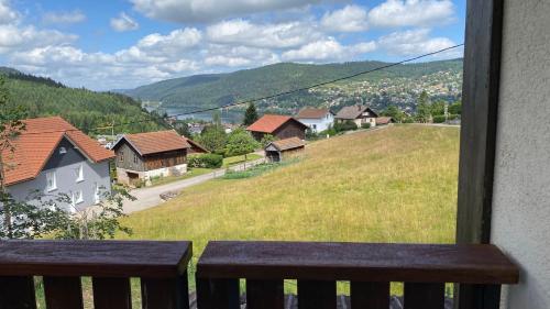 a view of a village from a balcony with a bench at Appartement Le Grand Duc in Gérardmer