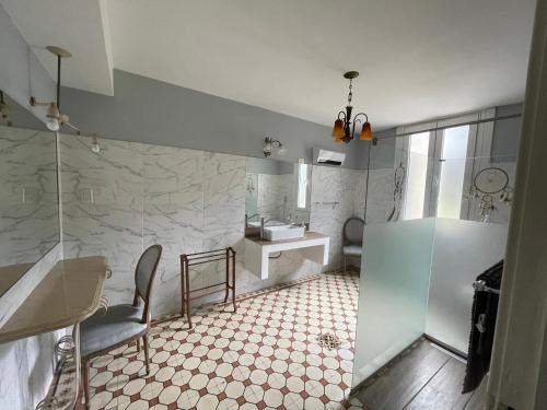 uma casa de banho com um chuveiro, um lavatório e um WC. em Chacras de Azcona Hostería em Azul