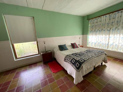 a bedroom with a bed and a large window at Chacras de Azcona Hostería in Azul