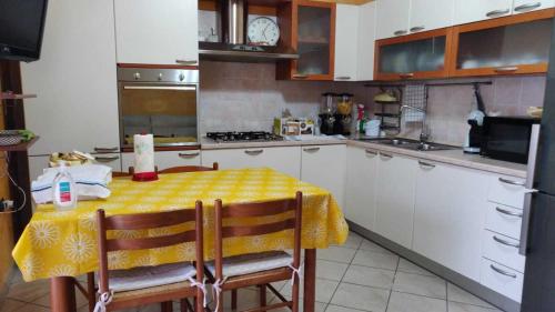 a kitchen with a table with a yellow table cloth on it at Aurora B&B in Gussola