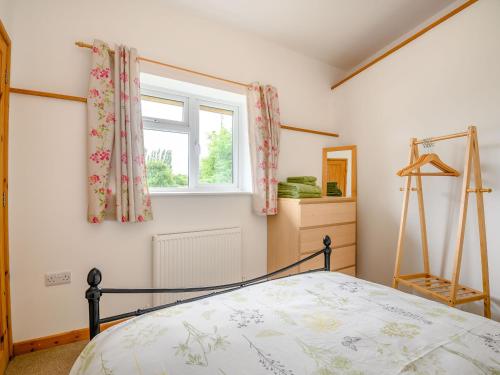Yorkley的住宿－The Stable Rose Cottage，一间卧室设有一张床和一个窗口
