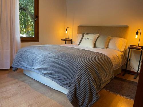 Un dormitorio con una cama grande y una ventana en Bella casa cercana al centro de ski y playas. en San Carlos de Bariloche