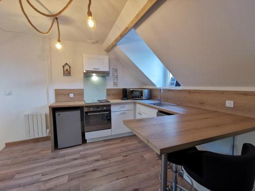 une cuisine avec des armoires blanches et une table en bois dans l'établissement Acapulco, Superbe souplex proximité vieille ville, à Boulogne-sur-Mer