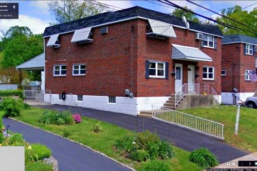 een rood bakstenen huis met zonnepanelen erop bij ABnB Superhost - Siri's Favorite Place in Havertown
