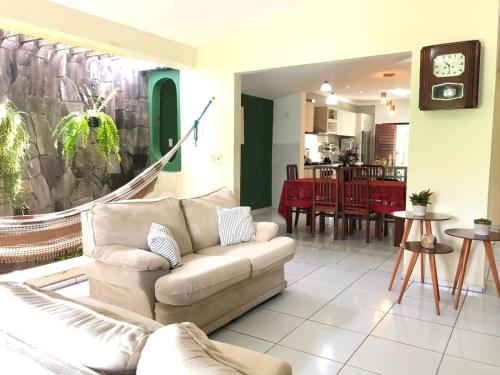 a living room with a couch and a dining room at Casa ampla e aconchegante no coração de Ponta Negra in Natal