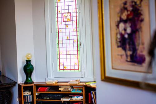 a stained glass window in a room with a book shelf at Chacras de Azcona Hostería in Azul