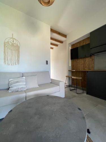 un soggiorno con un divano bianco e un tavolo di Aellw cozy apartment 2 a Néa Thésis
