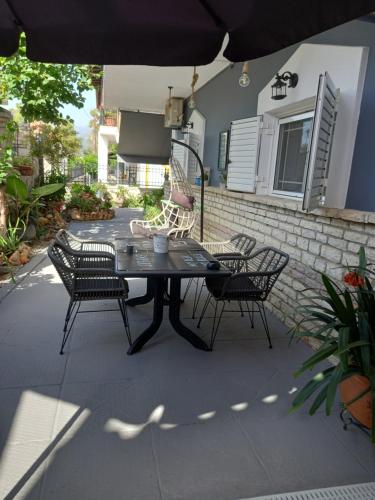 un patio con mesa, sillas y sombrilla en Kakovatos Family Homes, en Zacharo