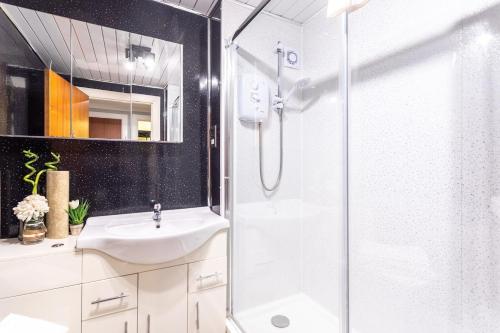 a bathroom with a glass shower and a sink at Glasgow merchant city oasis in Glasgow