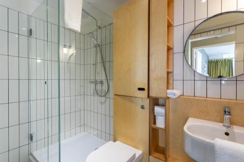 y baño con lavabo, aseo y espejo. en Merchant City Apartment, en Glasgow