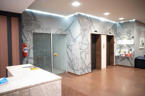 a bathroom with a wall with a painting on it at Plaza Blumenau Hotel in Blumenau