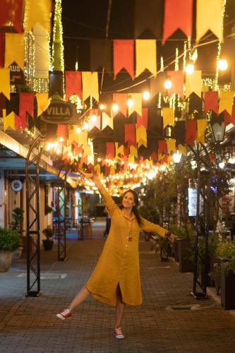 a woman in a yellow dress standing under lights at Plaza Blumenau Hotel in Blumenau